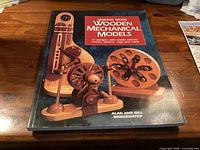 Front cover of the book showing title and wooden mechanism illustrations