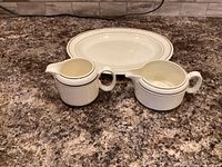 Top view of oval platter and two creamers showing pattern, color and condition