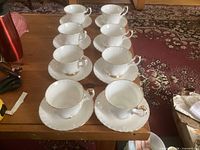 Eight Royal Albert Val D'Or teacups each on its saucer displayed on table