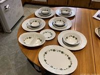 Full set of plates, bowls, platter and divided dish on table