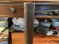 Spine view of black cloth hardcover book "Smithsonian Report 1888" showing gilt title and wear at spine top