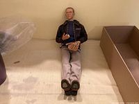 Full view of seated 12 in Steve McQueen figure with clothing and glove