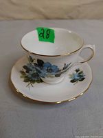 Royal Vale blue floral teacup on matching saucer, green lot sticker visible