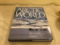 Front cover of The Arctic World hardcover book with title and authors visible