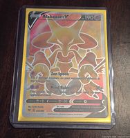 Front of sleeved Alakazam V card showing holographic finish and card details