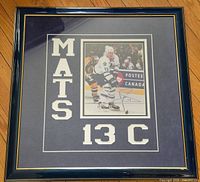 Full view of framed signed photo showing mat lettering and frame