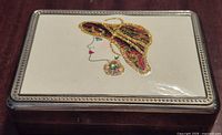 Closed box showing enamel Art Deco woman and beaded rim