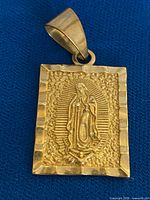 Front view showing raised Virgin of Guadalupe image, border, bail