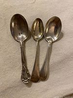 Front view of three sterling silver spoons
