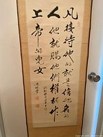 Full view of scroll showing calligraphy, seals, silk border, wooden dowels