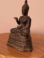 Front angled view of entire Buddha statue showing posture and base
