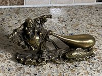 Front view of bronze Laughing Buddha figurine with sack and fish