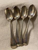 Four Birks sterling silver teaspoons with monogram visible
