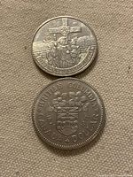 Both commemorative 1-dollar coins, reverse sides visible