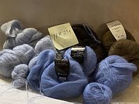 All eleven skeins in assorted colours with some labelled Drops Kid-Silk and Kid Seta visible