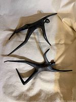 Both bronze abstract sculptures on fabric surface