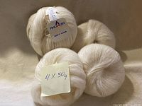 Four cream skeins with note 4 × 50 g visible