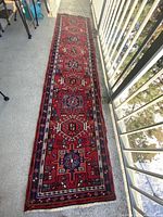 Full view of red Turkish runner rug laid flat on floor