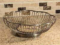 Empty silver-plated wire bowl on countertop