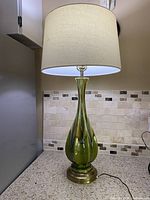 Full lamp view on countertop showing body, base, and shade lit