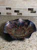 Top view of iridescent Northwood carnival glass bowl showing pattern and ruffled edge