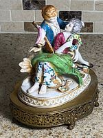 Front right view showing couple, colors, lute, bouquet, brass base detail