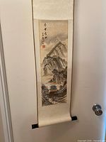 Full view of hanging Chinese scroll with silk mount and wood roller ends