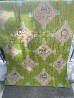 Full view of quilt front showing patchwork pattern and multiple embroidered character panels