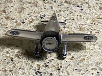 Full view of silver and black metal airplane desk clock with Fossil dial