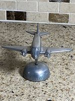 Front view of Fossil metal airplane on base