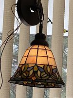 Full view of illuminated pendant showing stained glass pattern and colors