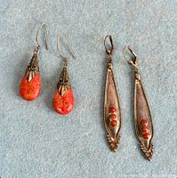 Both pairs of sterling silver coral earrings laid flat