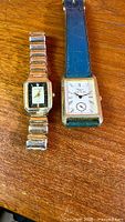 Both wristwatches side by side on wood surface