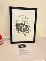 Framed print standing on surface showing full piece with document