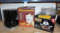 Three boxed appliances: black dehydrator, Welbilt bread maker box, air fryer box