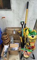 All items stacked: potting soils, shovels, hedge clippers, boxed items, bamboo shelf pieces