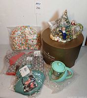 Group shot showing Waterford box, wrapped porcelain teapot, glass infuser teapot, and three sealed tea cozies