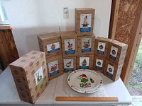 Group view of boxed Jim Shore train cars, Grinch plate visible