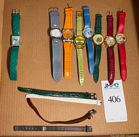 Tray showing nine wristwatches and four loose bands