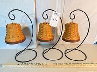 Front view showing three Longaberger bell baskets hanging on wrought iron stands