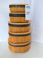 Stacked view of four Harmony oval baskets showing lid design and weave