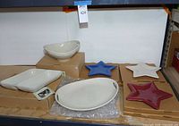 Overview of ivory bowls, tray and three star plates on shelf