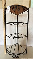 Full view of Longaberger wrought iron four-tier corner shelf showing scroll details and wooden top insert