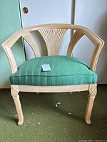 Front view showing chair frame, seat fabric, leg carving