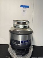 Full view of InSinkErator 555SS garbage disposal standing upright with label visible