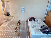 Full lot showing oil lamp, gold metal shelf brackets, boxed glass shelf and faux lamp components