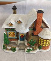 Front and side view of snow-covered ceramic house
