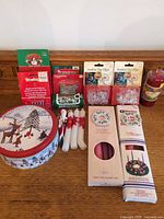 Overview of entire lot showing tin, candles, clips, hooks, bulbs and pillar candle