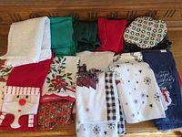 Full lot of Christmas kitchen linens displayed on wooden surface