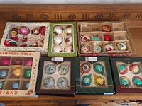 Seven boxes of assorted vintage glass ornaments on dresser top